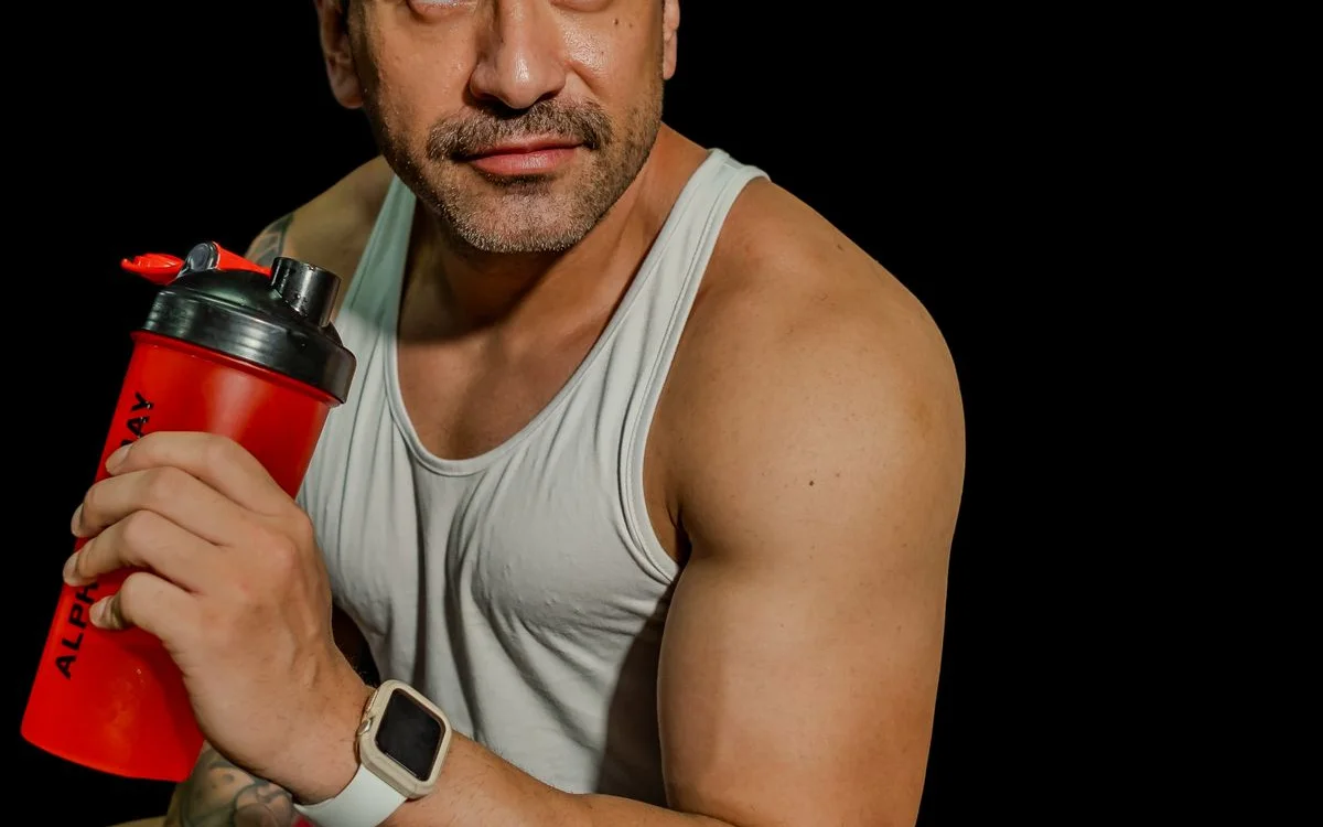 An athlete holding a shaker bottle after training