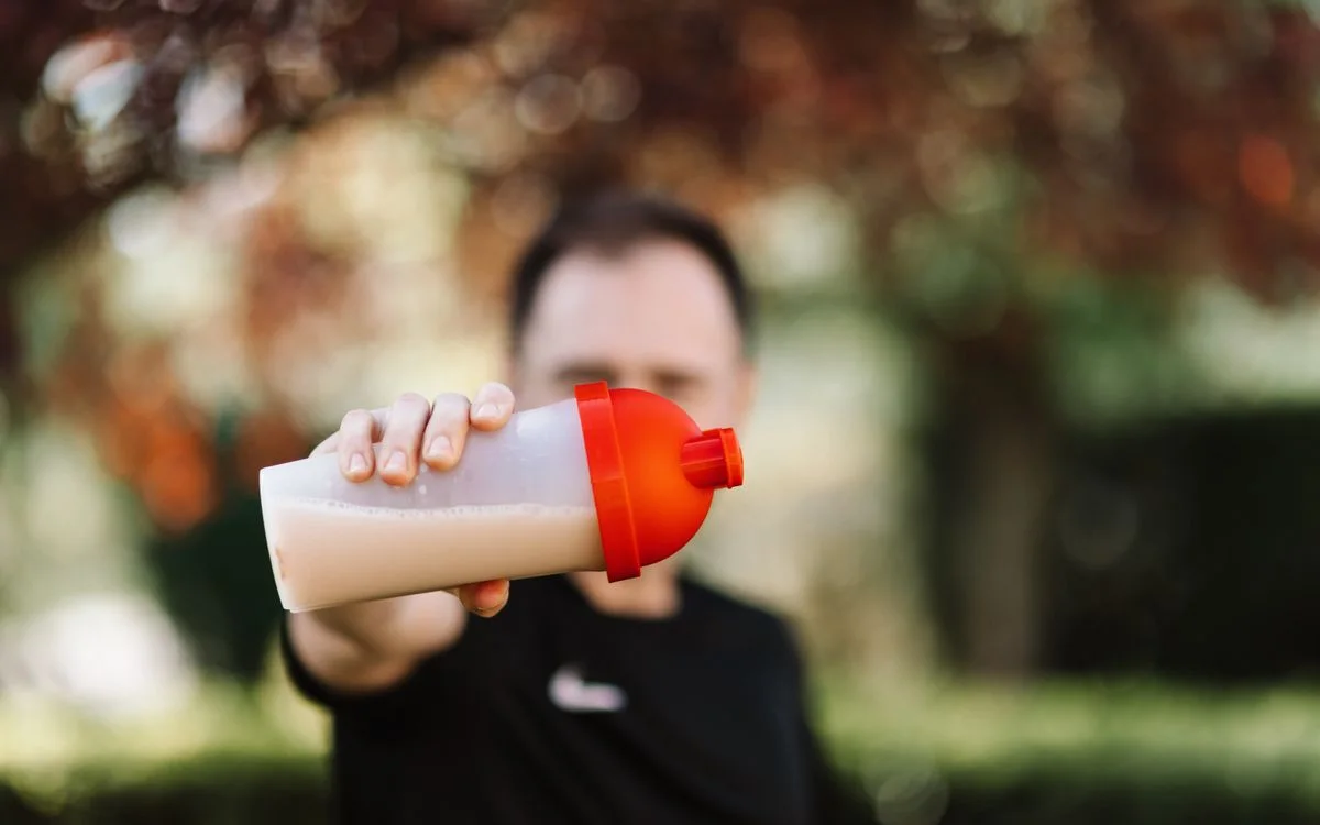 A runner with a shaker bottle outdoors