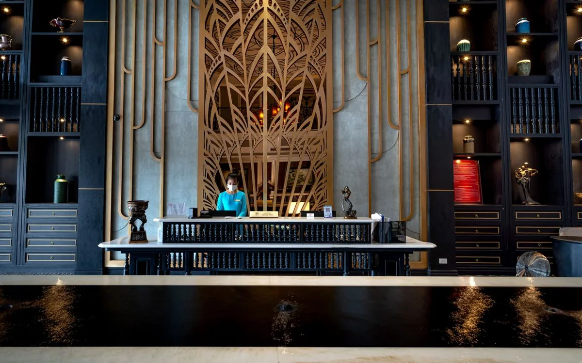 A receptionist at the front desk of a hotel lobby
