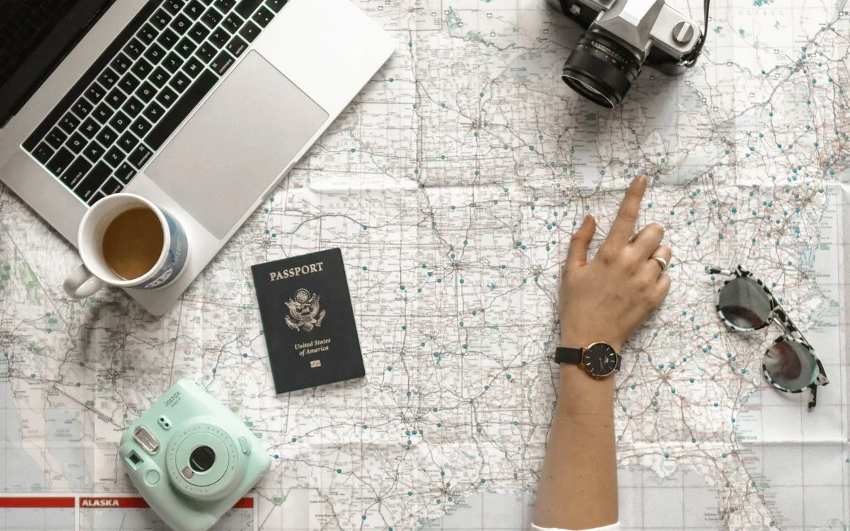Planning a trip with a map, camera and laptop